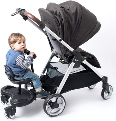 child using a buggy board with seat attached to a pushchair